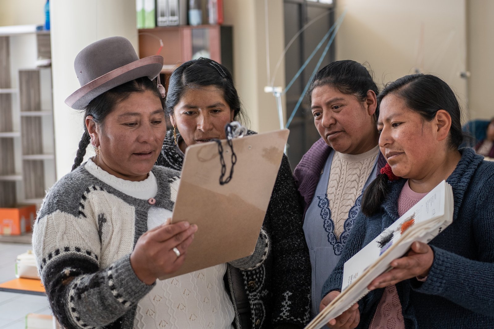 Artesanas revisando diseños de proyectos textiles - evaluación profesional