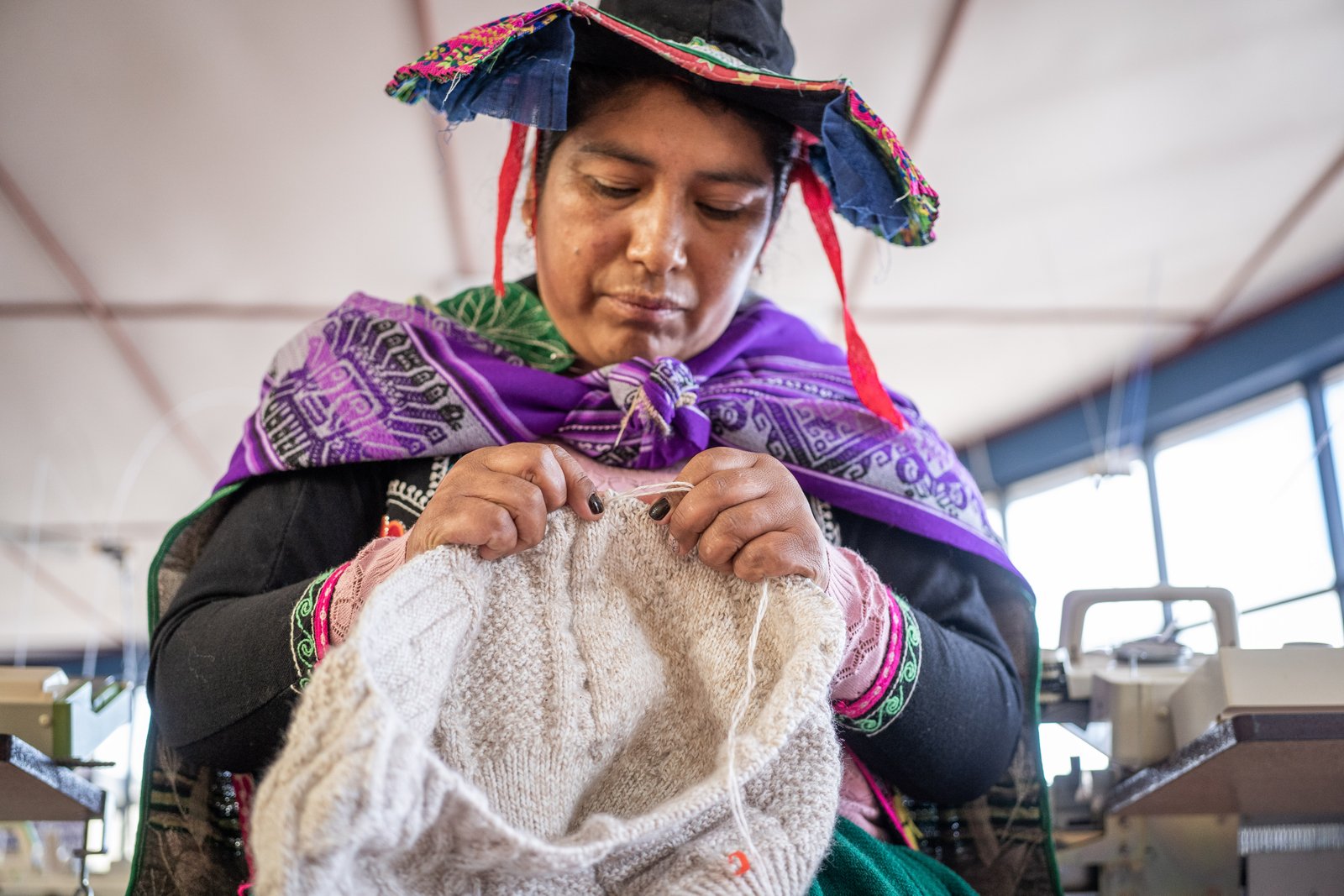 Artesana mostrando tejidos y productos de alpaca