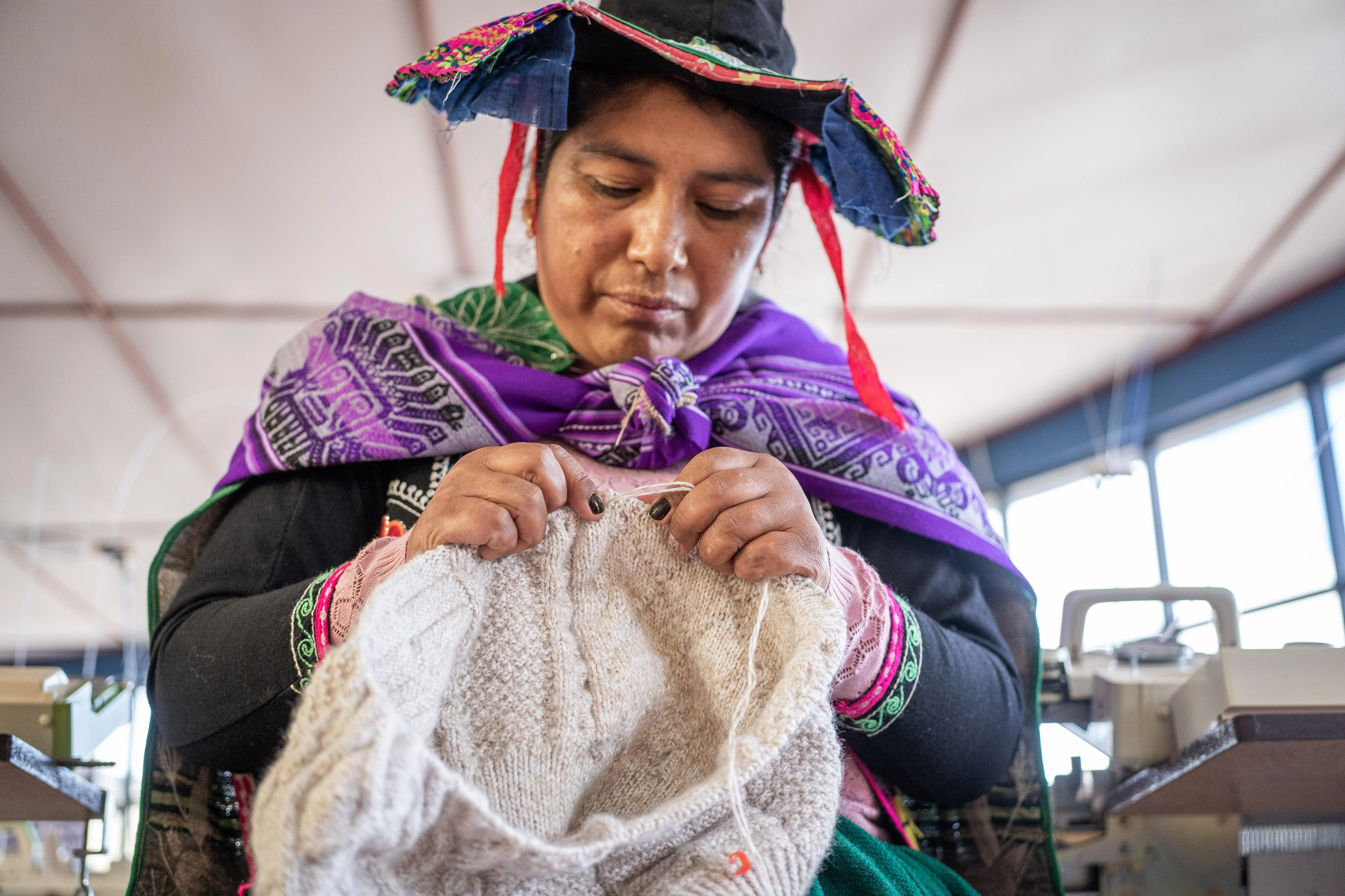 Artesana mostrando tejidos y productos de alpaca
