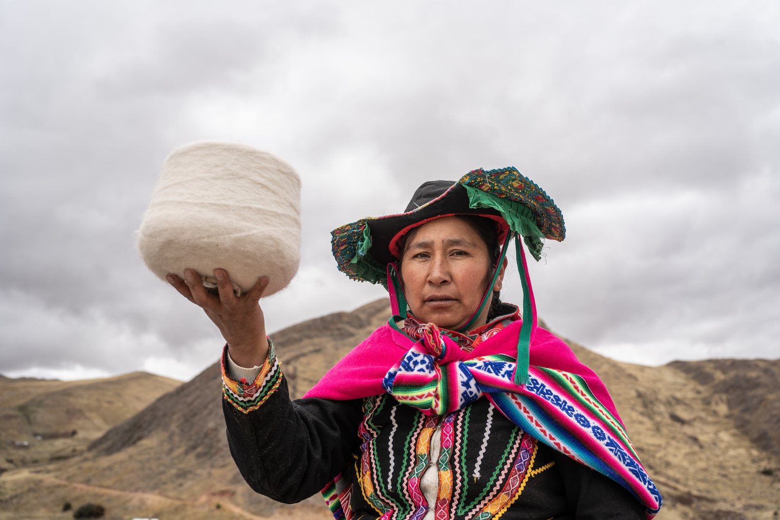 Artesana seleccionando hilado artesanal de alpaca en colores naturales